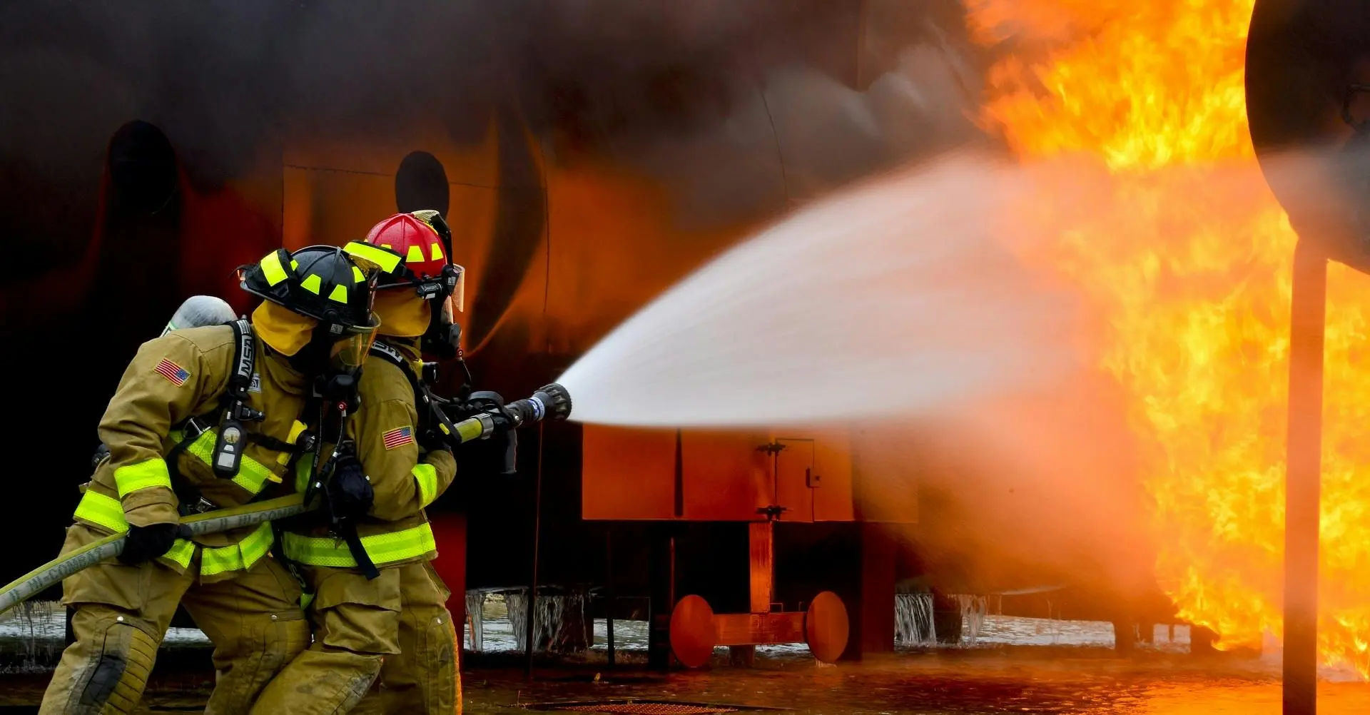 A photo of firefighters spraying water onto a fire